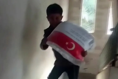 Kendi ağırlığı kadar un çuvalını taşıyan Filistinli çocuğun sevinci